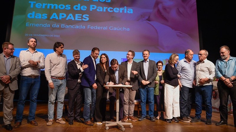 Grupo de pessoas reunido para assinatura de documento